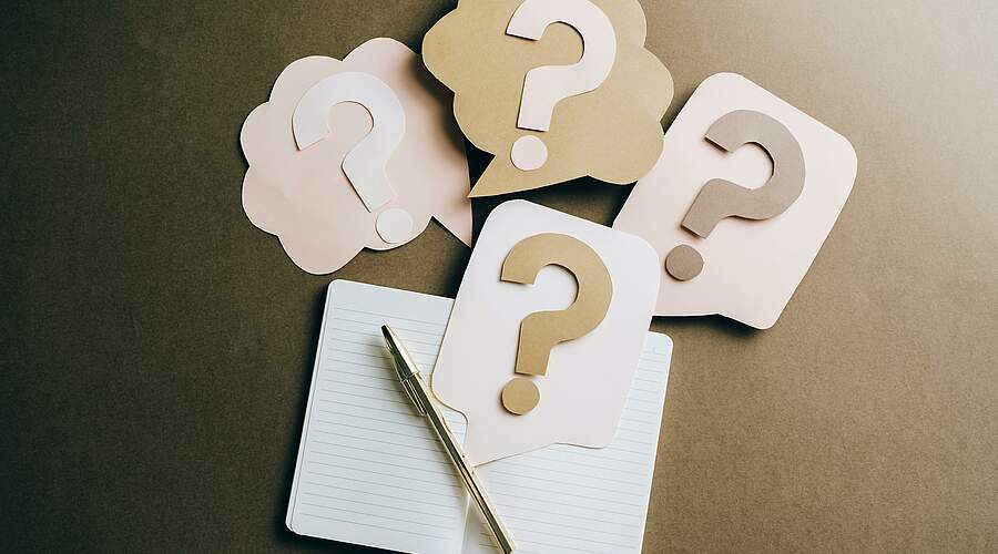 Notepad surrounded by question marks